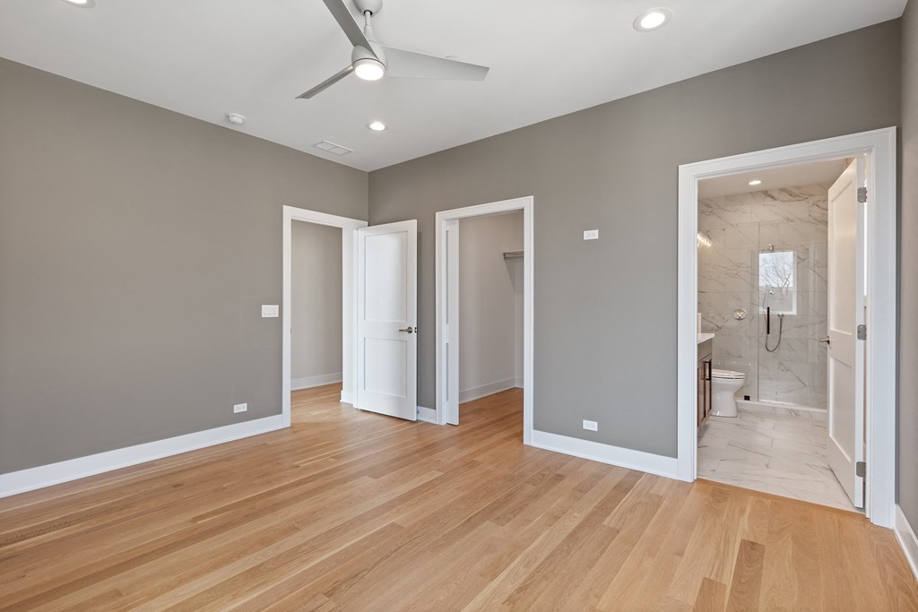 a renovated living room with a hard wood floor and grey walls