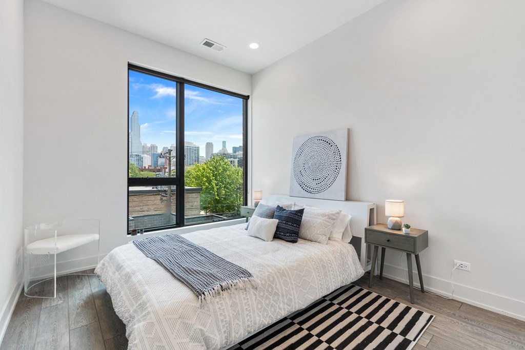 A bedroom with a large bed and a large window