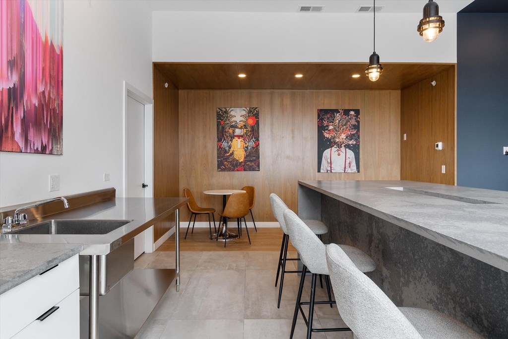 a kitchen with a long counter top and a dining area in the background