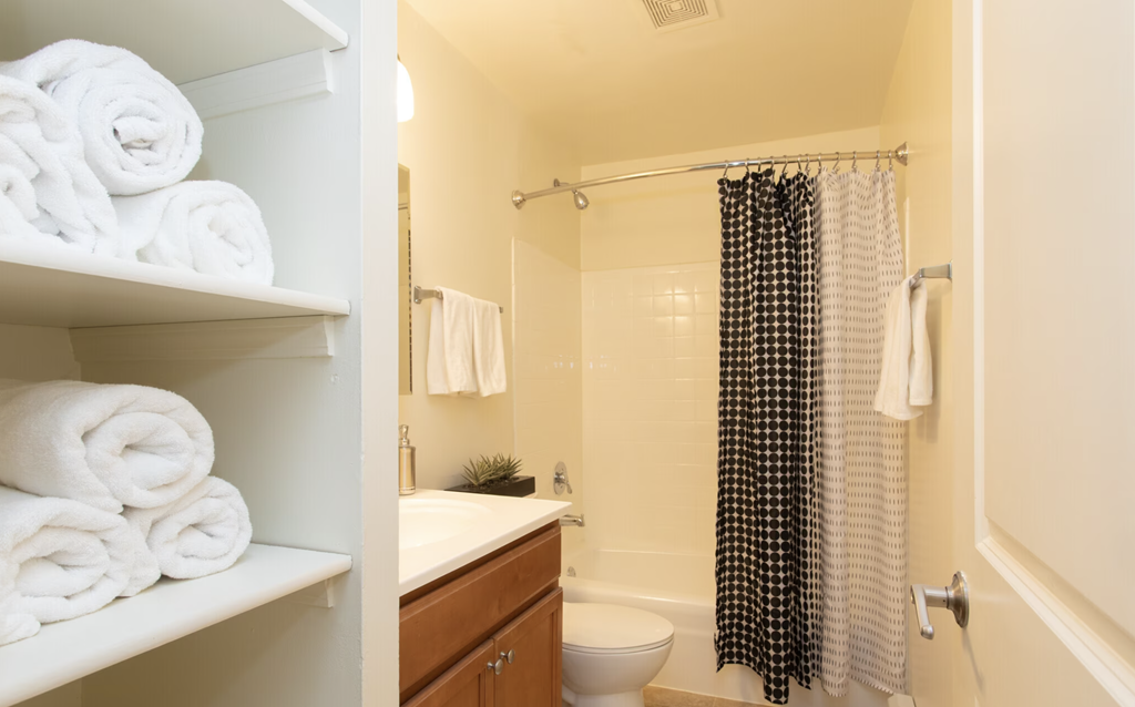 a bathroom with white towels and a shower and a sink