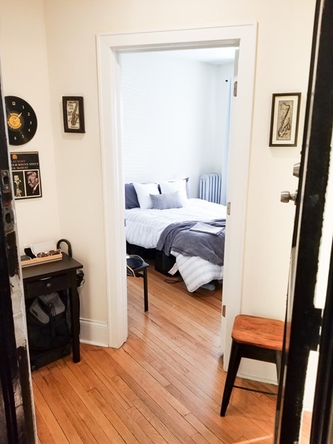 A bedroom with a bed, a desk, and a chair.