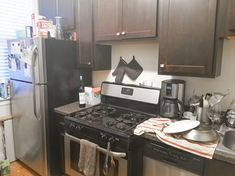 A kitchen with a black stove top oven and a black refrigerator.