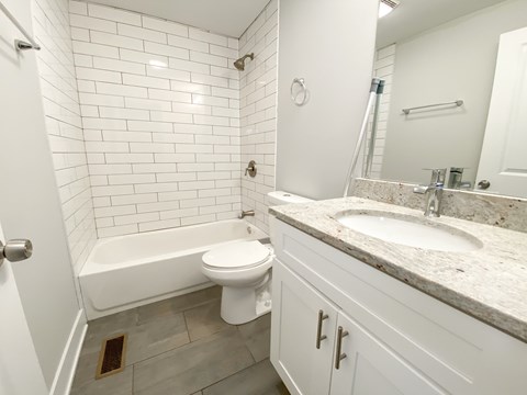 A white bathroom with a toilet, sink, and bathtub.