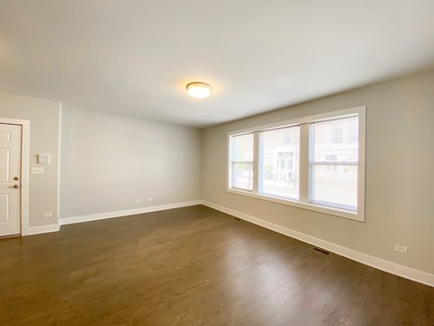 A room with a wooden floor and a window.