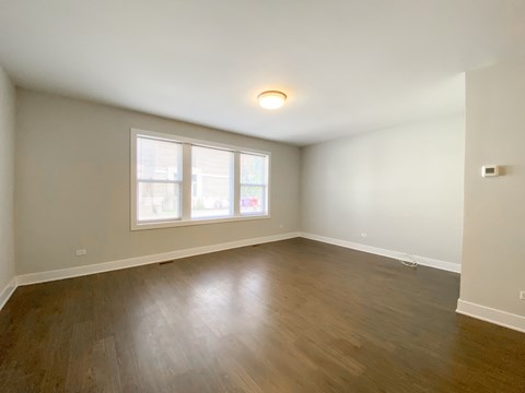 Empty room with wooden floor and a window.