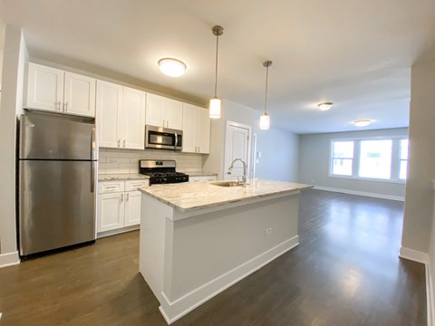 A kitchen with white cabinets and a stainless steel refrigerator.