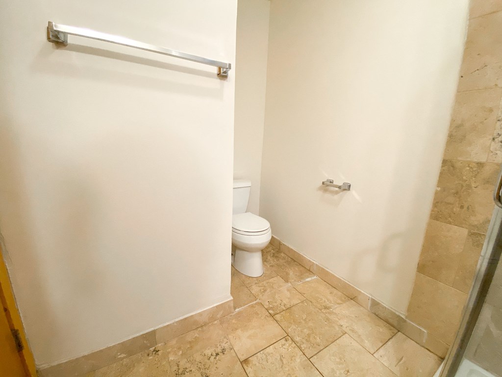 a bathroom with a toilet and a roll of toilet paper