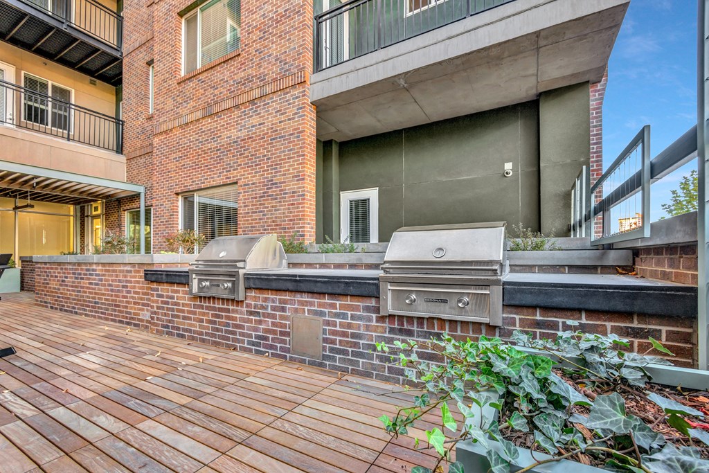 the outdoor patio has a barbecue grill and a wooden deck