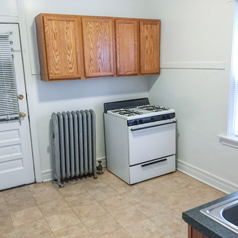 A white stove and oven in a kitchen with wooden cabinets.