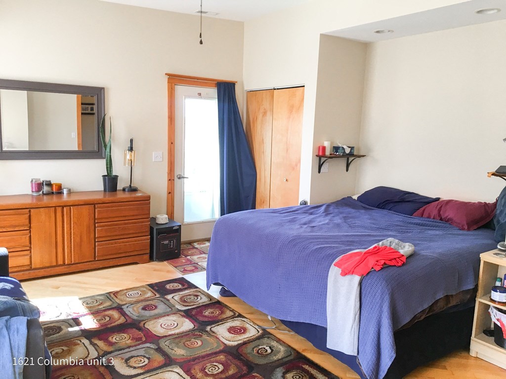 a bedroom with a bed and a dresser and a mirror