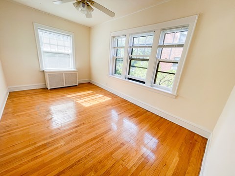 A room with wooden floors and two windows.