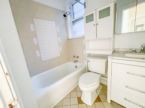 A white bathroom with a tub, toilet, and sink.