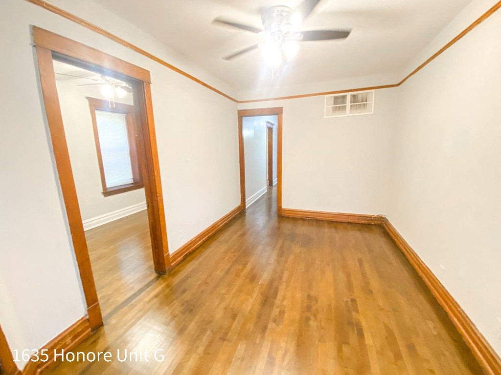 a empty living room with wood floors and white walls