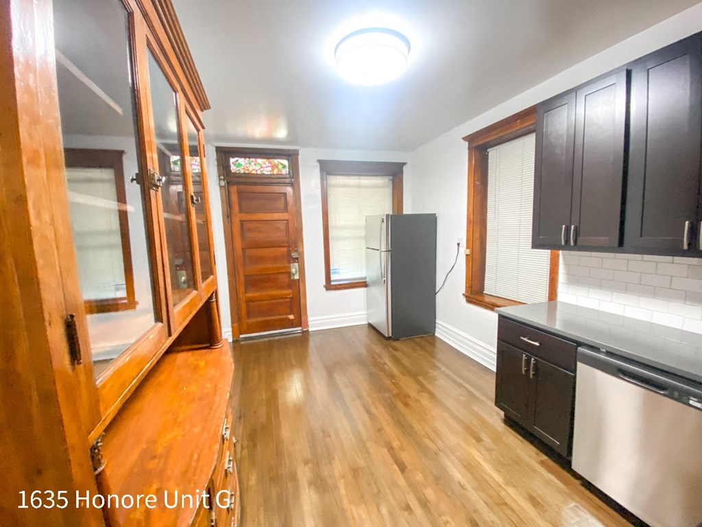 a kitchen with wood floors and black cabinets