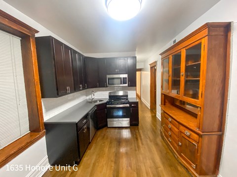 a kitchen with black cabinets and a white counter top