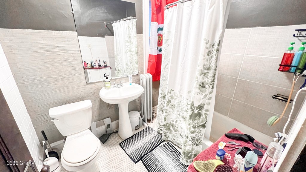 a small bathroom with a sink toilet and shower