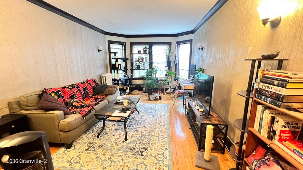 a living room with a couch and a tv and a window