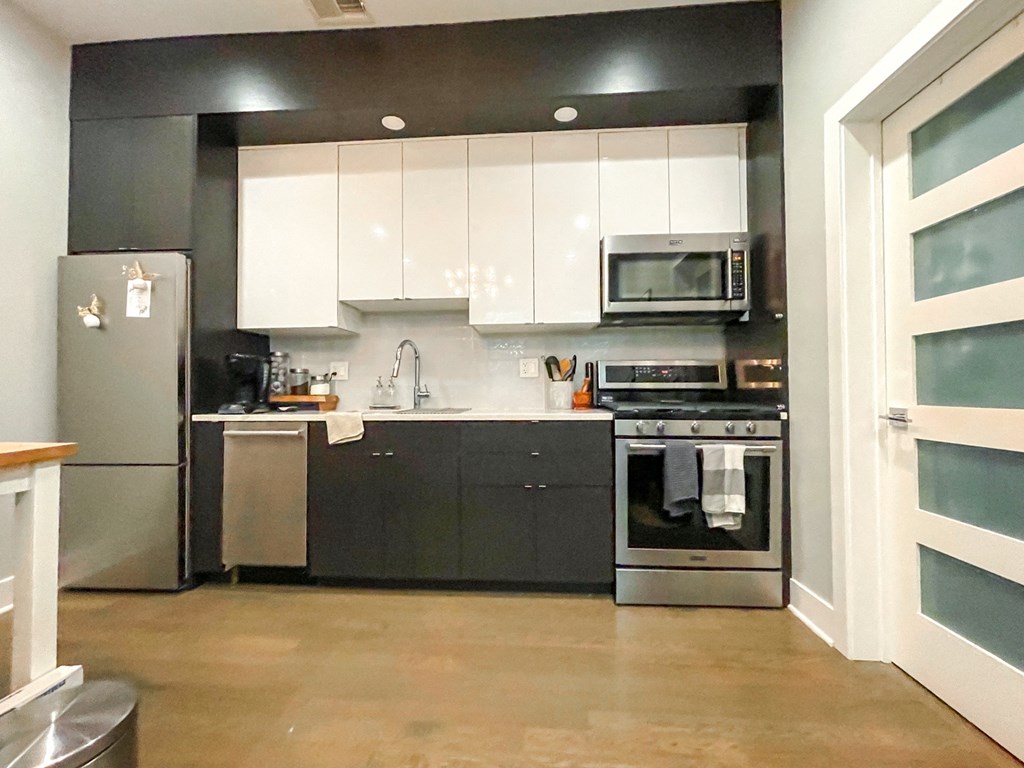 a kitchen with white cabinets and stainless steel appliances