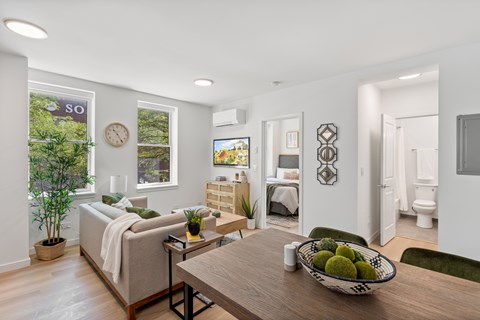 A modern living room with a wooden table and a bowl of fruit on it.