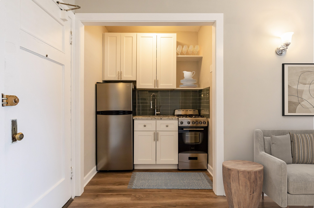 a small kitchen with stainless steel appliances and white cabinets