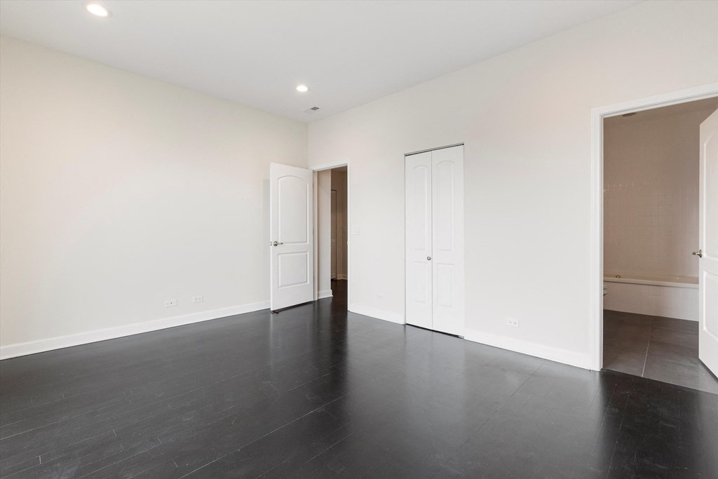 a bedroom with white walls and a black floor