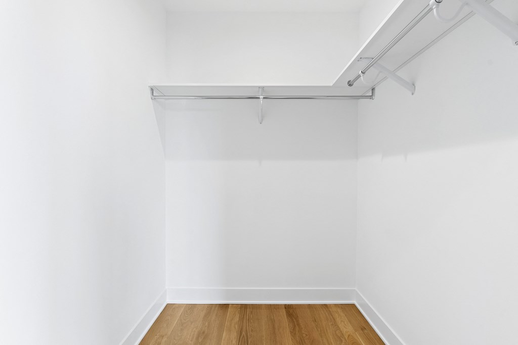 an empty room with white walls and a wood floor
