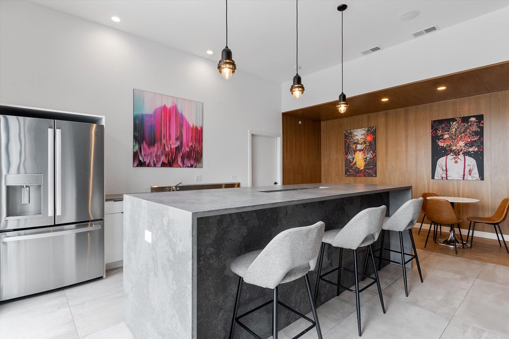 a kitchen with a large island with three stools in front of it