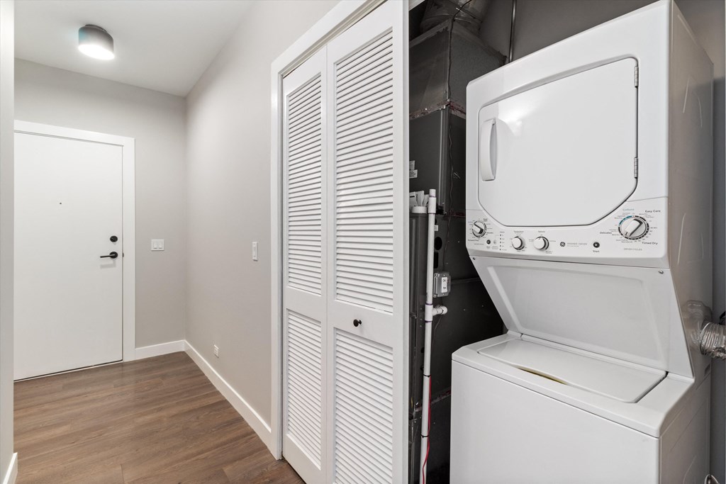a laundry room with a washer and dryer and a door to a closet
