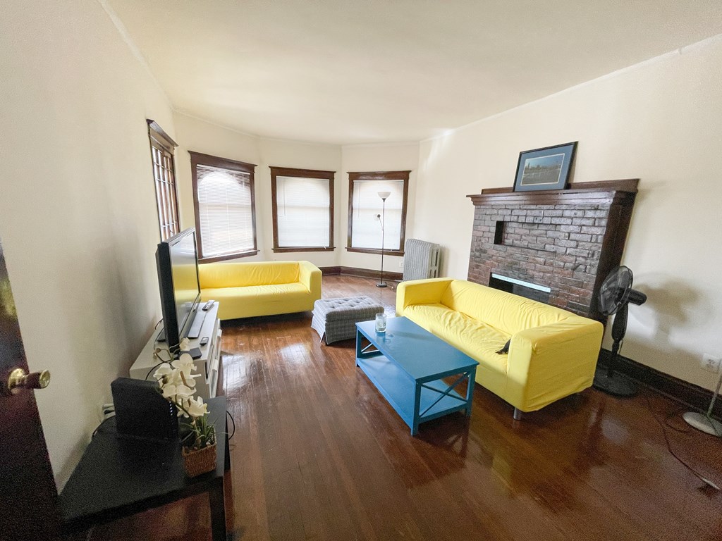 A living room with a yellow couch and a blue coffee table.