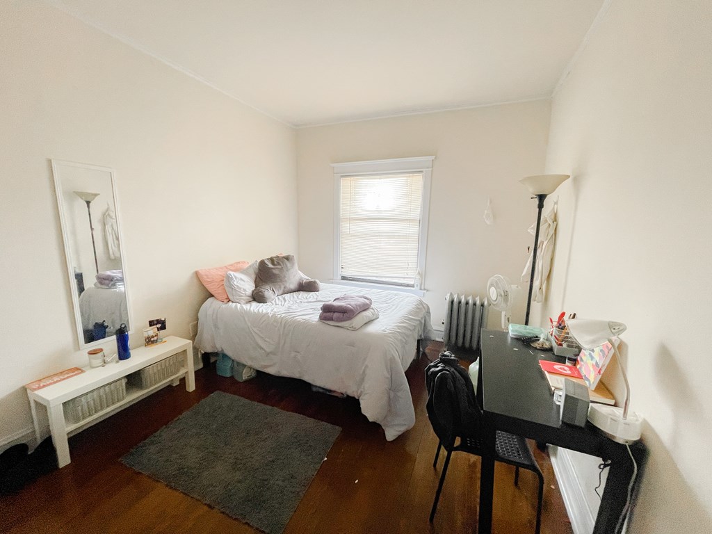 A bedroom with a bed, desk, and chair.