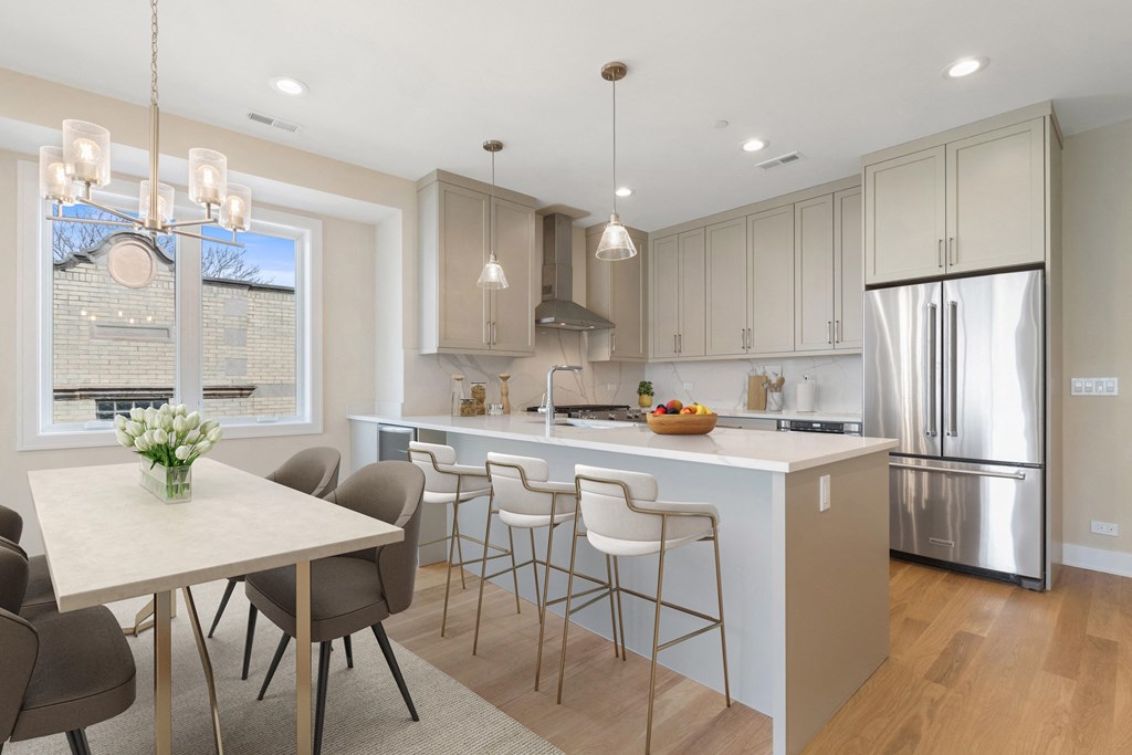 a kitchen with a large island and a table with chairs