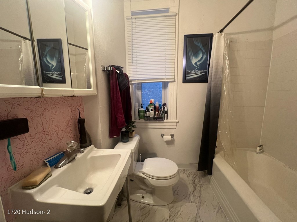 a bathroom with a toilet and a sink and a shower