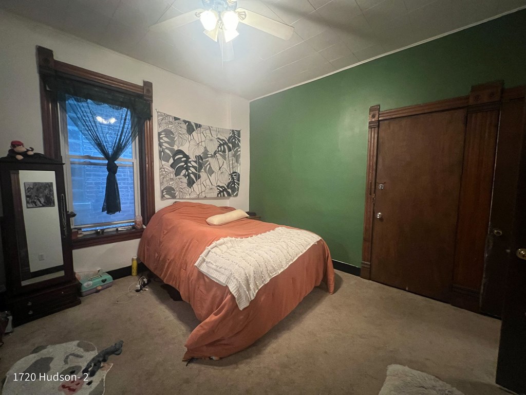 a bedroom with a bed and a green wall and a window