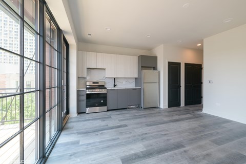 A modern kitchen with a large island and a refrigerator.