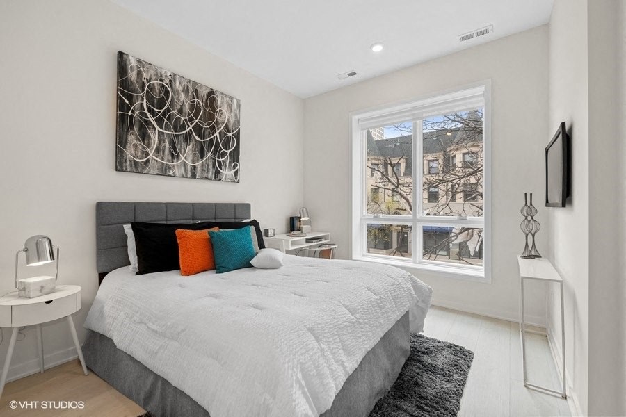 a bedroom with a bed and a large window