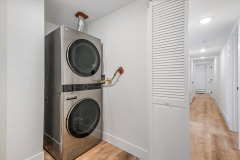 A modern laundry room with a washer and dryer built into the wall.