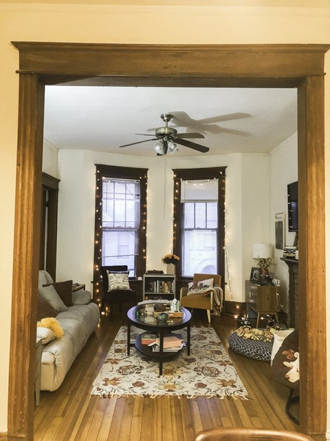 a living room with a ceiling fan and a large mirror
