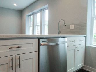 a kitchen with white cabinets and a stainless steel dishwasher - Photo Gallery