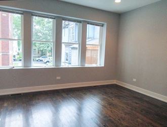 a bedroom with a large window and hardwood floors - Photo Gallery