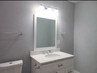 a bathroom with a sink mirror and toilet - Photo Gallery