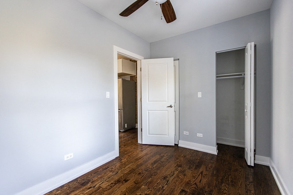 an empty room with a closet and a ceiling fan