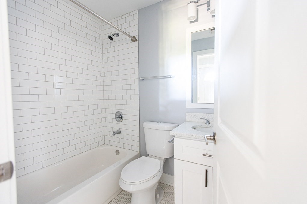 a white bathroom with a tub toilet and sink