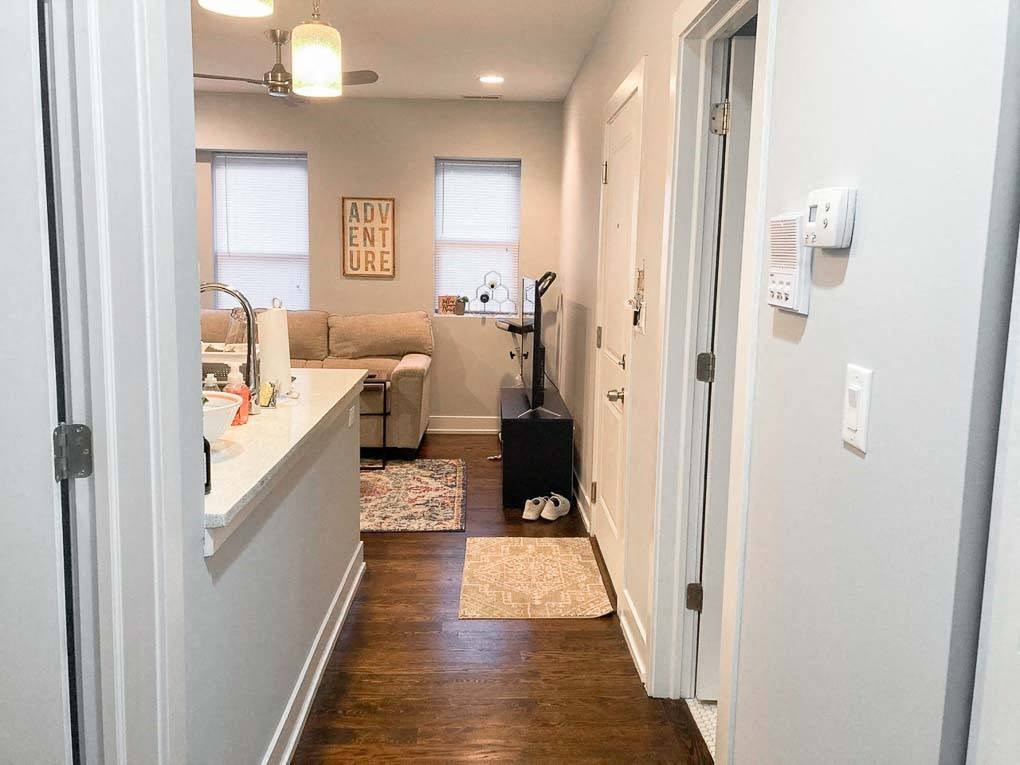 a hallway with a kitchen and a living room with a suitcase