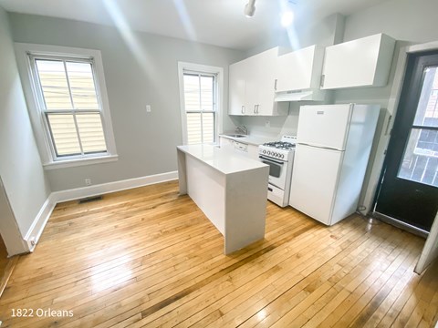 A kitchen with wooden floors and white appliances.