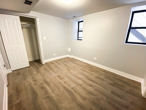 A room with a wooden floor and a white door.