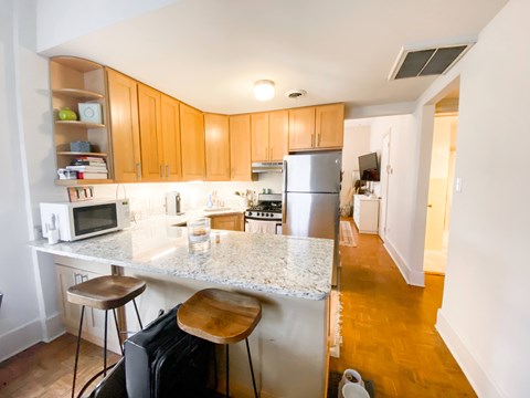 A kitchen with a white counter top and wooden cabinets.