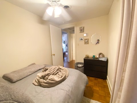 A bedroom with a bed, dresser, and mirror.