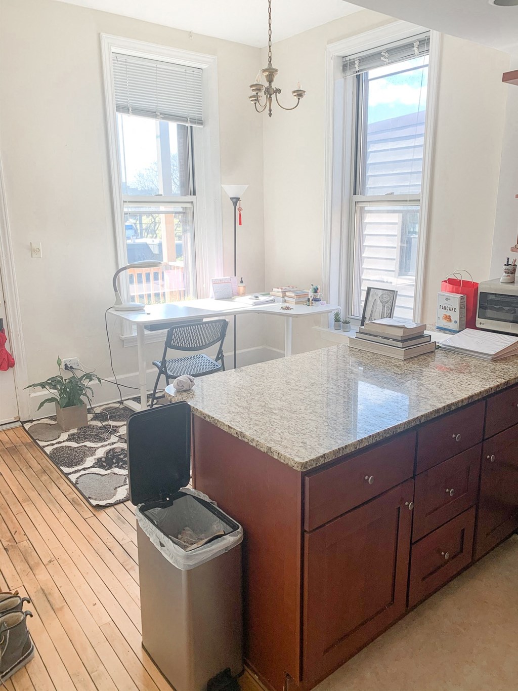 a kitchen with a counter top and a trash can