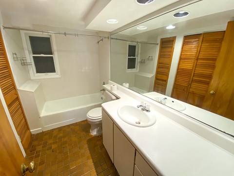 A bathroom with a white sink, toilet, and bathtub.