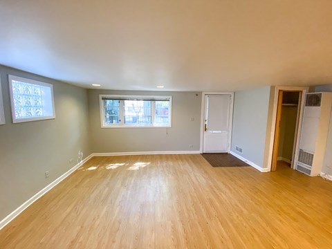 A room with wooden flooring and a window.